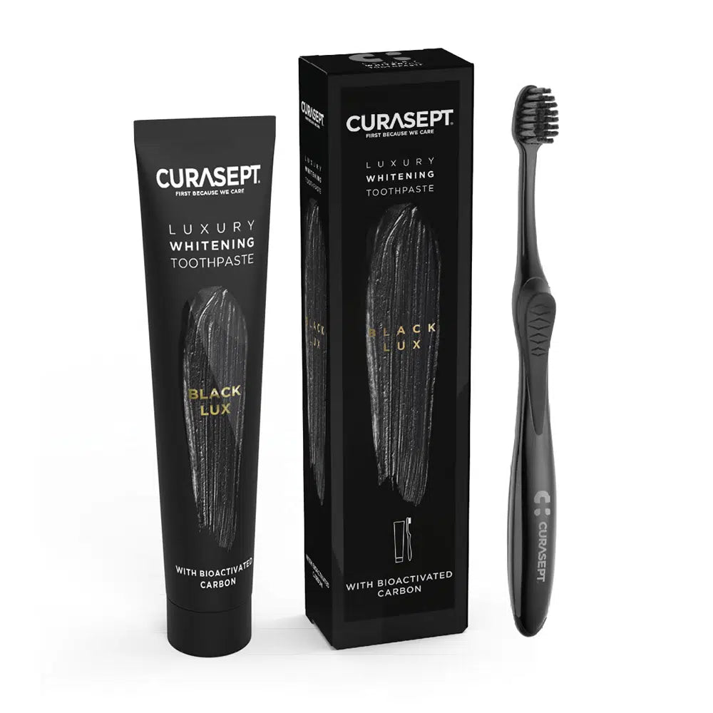 Curasept Black Lux toothpaste tube, packaging, and toothbrush on a white background